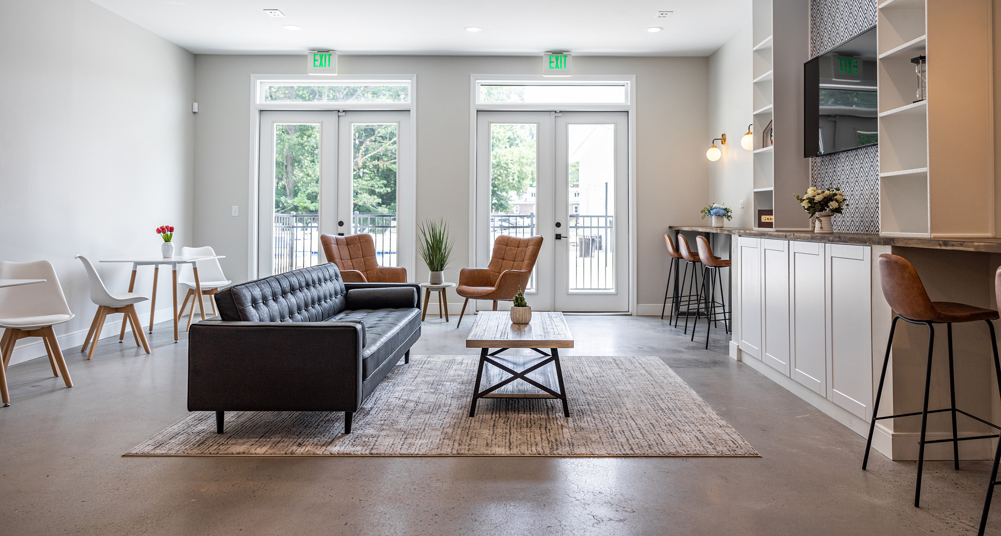 a living room with a couch and a table and a kitchen with doors
